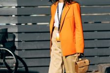 15 a white t-shirt, tan high waisted wideleg pants, an oversized orange blazer, a tan saddle bag