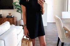 21 a black mini t-shirt dress with short sleeves, a woven bag and brown slides is a lovely casual look