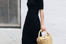 22 a minimalist look with a black A-line t-shirt midi dress with short sleeves, white snakers and a basket bag