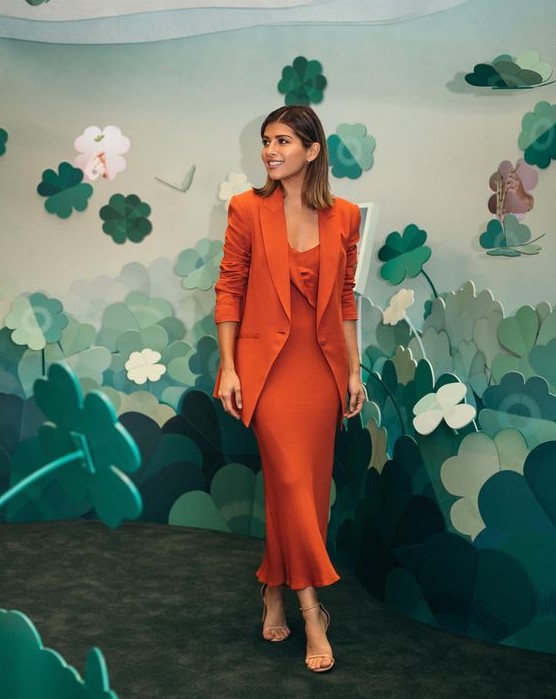 a bold and elegant monochromatic work look with an orange slip midi dress and a matching blazer, nude strappy shoes