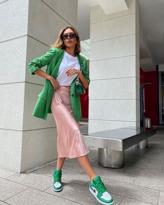 a bold work look with a white t-shirt, a blush slip midi skirt, green and white trainers, a green blazer and a green bag