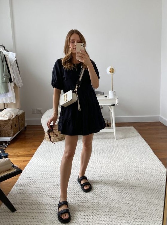 a black cotton A-line dress, black birkenstocks and a white bag with a gold logo are a chic combo for every day