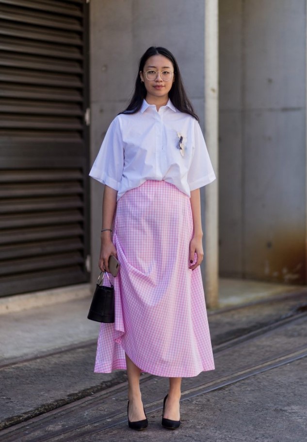 a crispy white blouse with short sleeves, a pink gingham midi, black heels and a bucket bag for a cute look