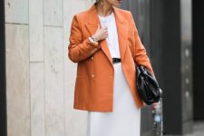 29 a white t-shirt, a neutral midi slip skirt, an orange oversized blazer, a black bag and black heels