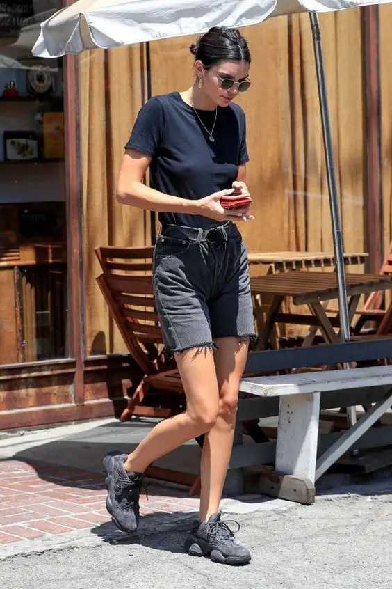 Kendall Jenner wearing a black t shirt, black denim shorts and a black belt looks simple and very cool