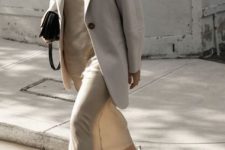 With beige linen loose blazer, black leather bag and white, brown and green sneakers