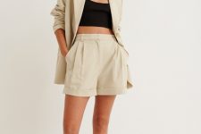 With beige linen shorts and black leather flat sandals