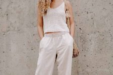 With beige sleeveless loose top, beige fishnet bag and brown leather flat sandals