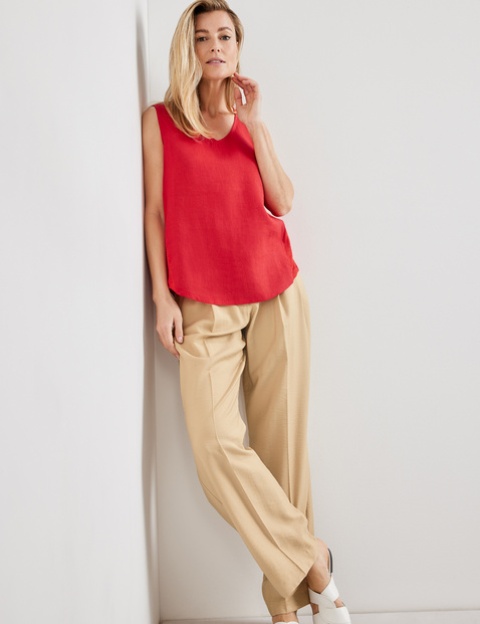 With beige trousers and white leather flat sandals