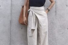 With earrings, navy blue sleeveless top, brown tote bag and high heels