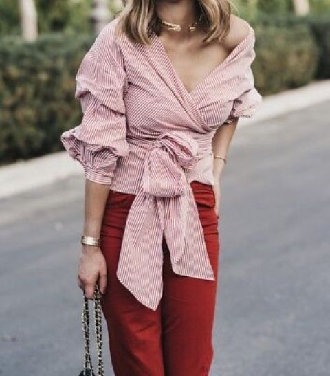 With golden necklace, chain strap bag and red jeans