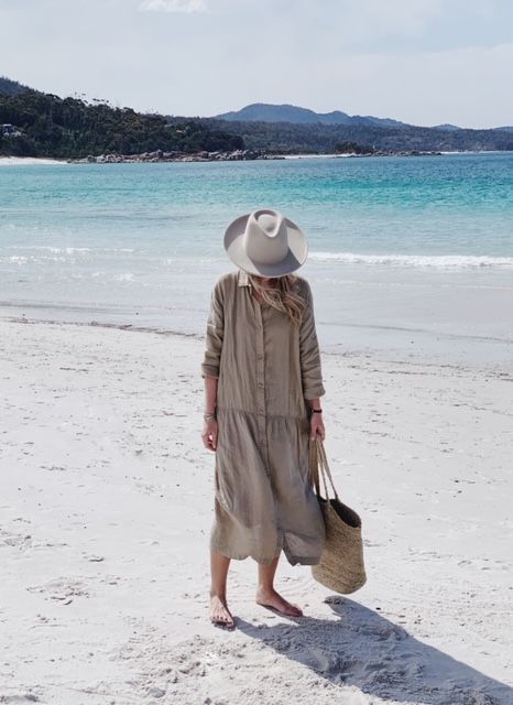 With light gray wide brim hat and beige straw tote bag
