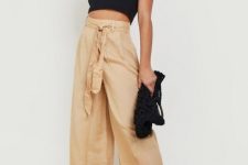 With oversized sunglasses, black crop top, golden necklace, black knitted bag and black sandals