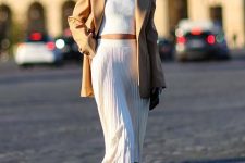 With oversized sunglasses, necklace, white high-waisted pleated midi skirt and printed mid calf boots
