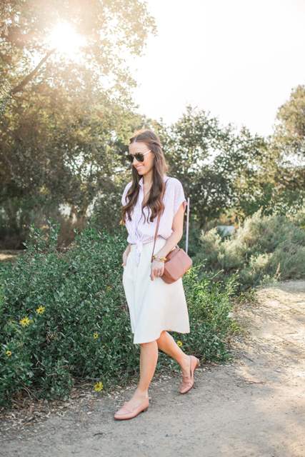 With sunglasses, brown leather bag, beige midi skirt and pale pink leather flat shoes