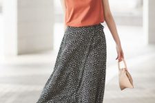 With sunglasses, golden necklace, beige leather mini bag, black and white polka dot midi skirt and brown sandals