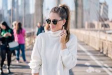 With sunglasses, white loose sweater and brown leather bag