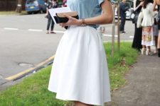 With white A-line knee-length skirt, clutch and black ankle strap high heels
