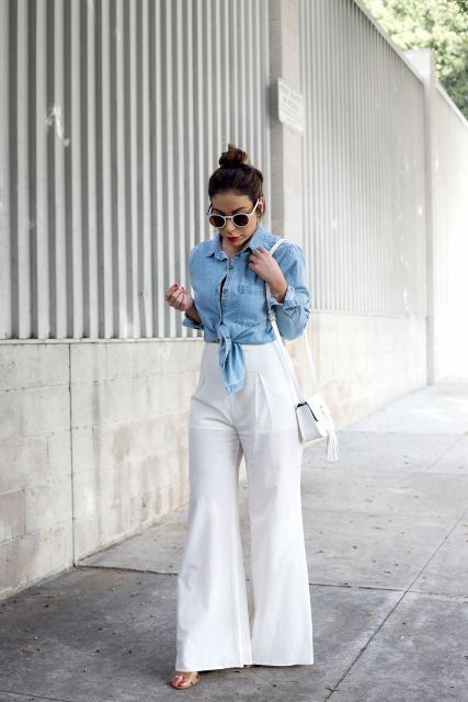 With white framed rounded sunglasses, black top, light blue denim jacket, white leather tassel mini bag and beige shoes