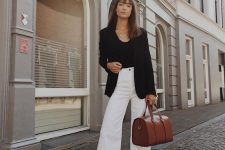 a black top, a black blazer, white flare jeans, brown sldies and a brown bag for a cool work look