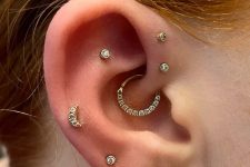 a bold and glam ear set with a double forward helix, a flat, a daith, multiple lobe piercings, with hoops and studs