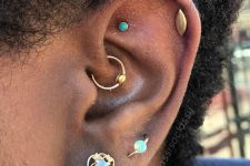 a bold ear with a faux rook, a helix, a daith, a lobe and an orbital piercing done with a set of earrings and studs