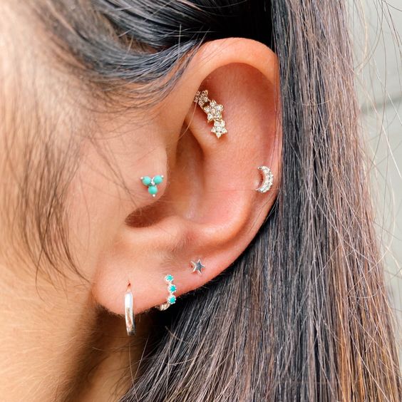 a bright and stylish ear stack with a faux rook, tragus, helix and triple lobe piercing all done with lovely studs and hoops