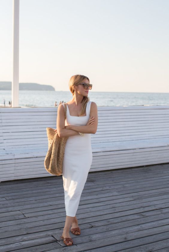 a coastal outfit with a white midi tank dress with a square neckline, a large woven bag, brown slides is cool