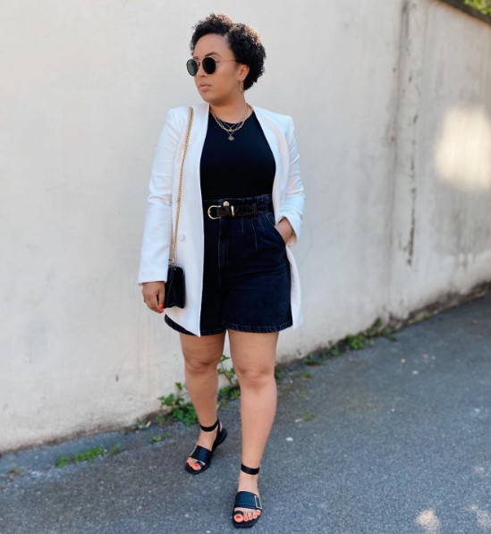 a contrasting summer look with a black t shirt, denim shorts with pockets, strpapy platform shoes, a white blazer and a black bag