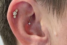 a double lobe, flat and hidden rook piercing all done with studs, a hoop and a chain piece of jewelry for a unique look