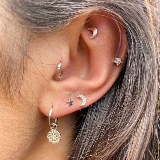 a lovely boho ear look with a faux rook, helix, triple lobe and a tragus piercing done with white gold studs and hoops