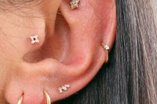 a lovely ear look with a faux rook, helix, multiple lobe and tragus piercing done with gold hoops and studs is a gorgeous idea to rock