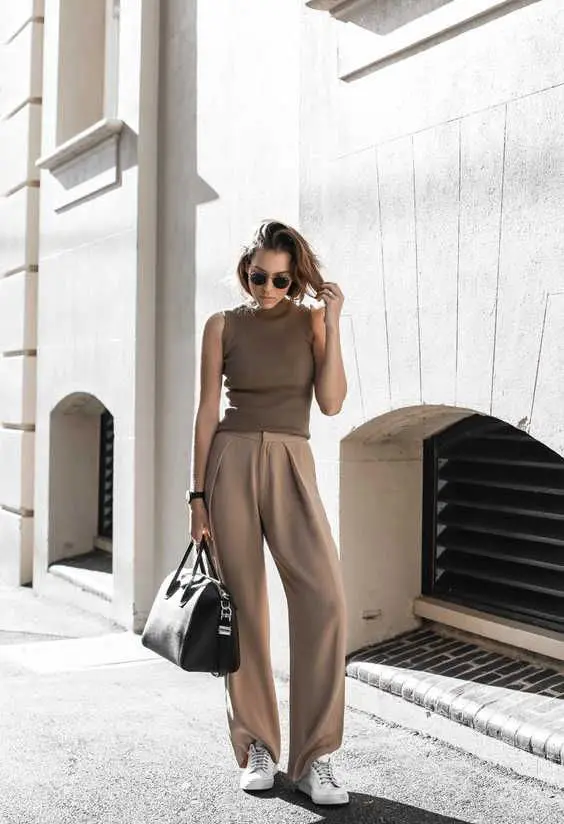 a minimalist summer look with a taupe sleeveless top, beige wide leg pants, white sneakers and a black bag