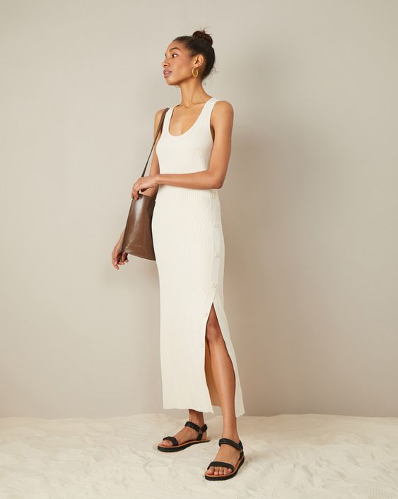 a minimalist summer outfit with a creamy tank midi dress with a slit on buttons, black sandals and a brown tote