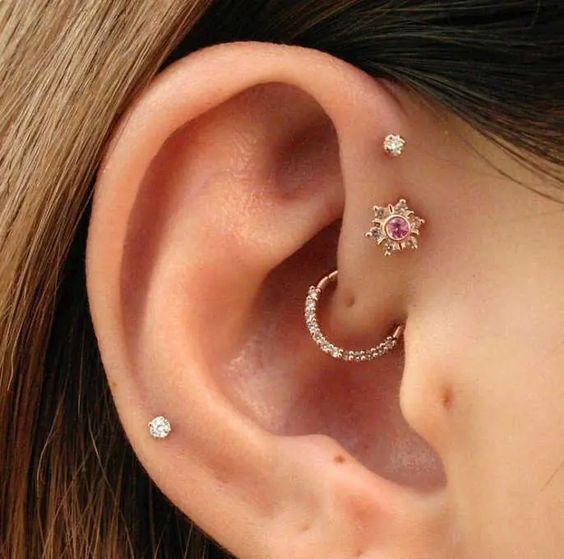 a pretty ear look with a double forward helix, a daith and a helix piercing all done with studs and a hoop