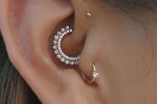 a refined ear set with a triple forward helix piercing, a daith, tragus and lobe one, all done with matching studs and hoops