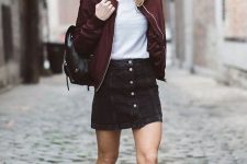 a simple and cute look with a white t-shirt, a black button up denim mini, white sneakers, a burgundy bomber jacket and a black backpack