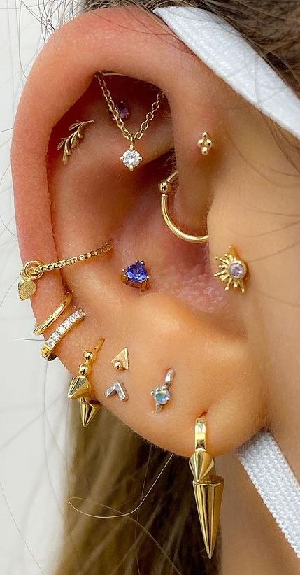 a super bold ear with multiple piercings, a hidden helix, forward helix, tragus, conch, flat and mutiple lobe piercings done with various studs and hoops
