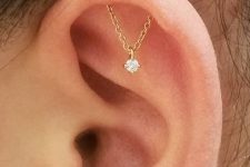 a super delicate hidden helix piercing with a gold chain with a rhinestone piece is a unique idea to go for