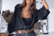 a total black look with a top, denim shorts, a black shirt, a brown belt and layered necklaces