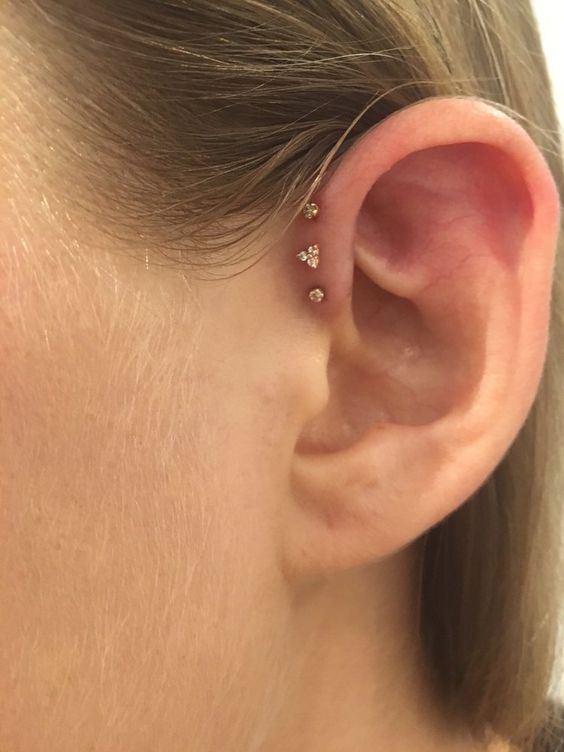 a triple forward helix piercing done with matching gold studs is a lovely idea for a modern look, no other piercings required
