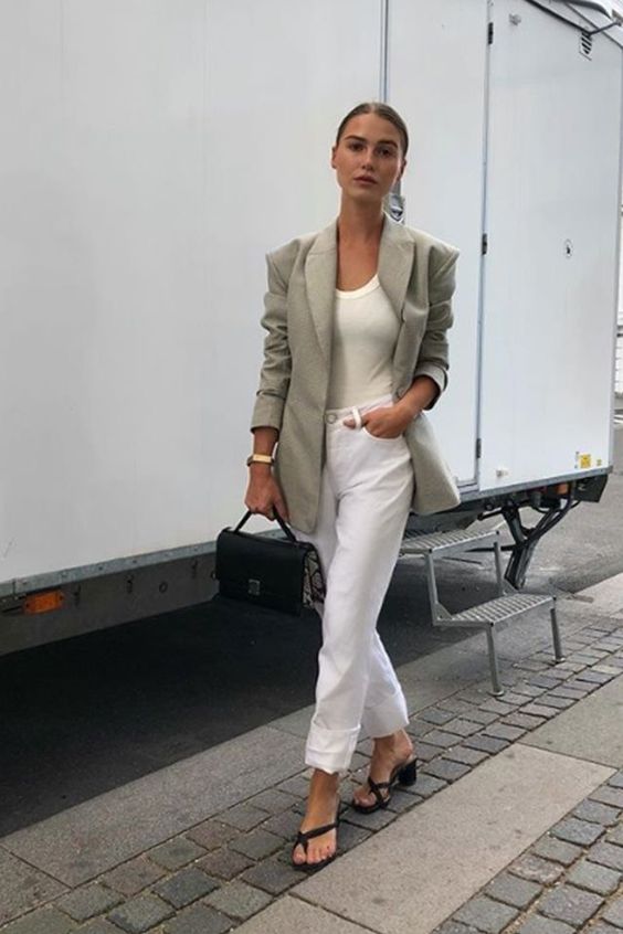 a white top, white cuffed jeans, black heeled shoes, an olive green blazer and a small black bag for summer