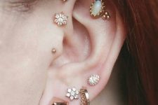 an extra bold ear look with a double forward helix, a double flat, a tragus and multiple lobe piercing with various earrings