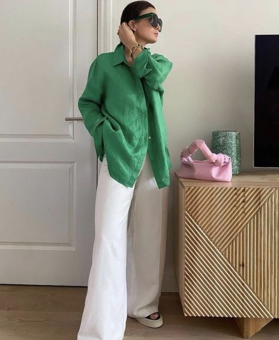 an oversized green shirt, white wideleg pants, platform shoes and a small pink bag for maximal comfort