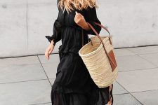 02 a black maxi dress with long sleeves, black flipflop sandals, a straw tote bag and a black hat for a bold and contrasting look