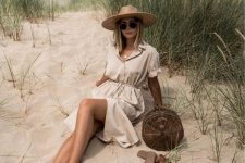 05 a neutral linen midi dress with buttons, a wide brim straw hat, a rattan round bag and brown slides