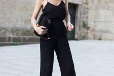 12 a super simple and chic total black look with a spaghetti strap top, cropped pants, slippers and an elegant bag