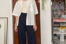 18 a casual and minimalist look with an ivory tank top, a white shirt, navy high waisted pants and ivory sneakers