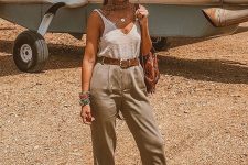 22 a creamy knit tank, khaki pleated pants, cap toe espadrilles, a straw hat and a brown leather bag