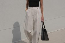 25 a minimalist black and white look with a black asymmetrical top, white wideleg pants, black sandals and a black bag